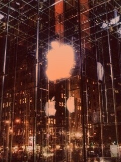 Отражение логотипа Apple в стеклянном здании обои