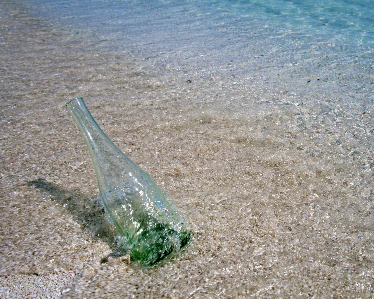 Бутылка в песке у воды обои