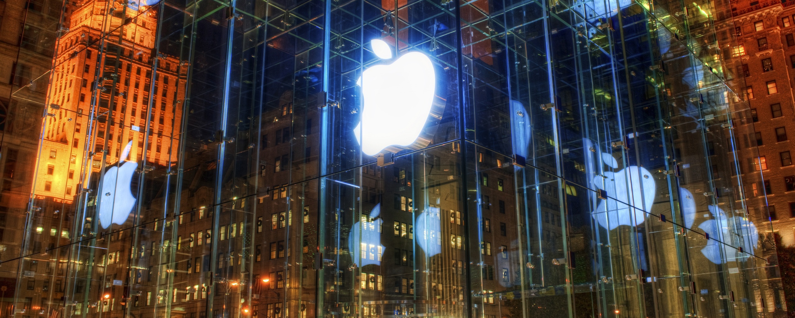 Отражение логотипа Apple в стеклянном здании обои